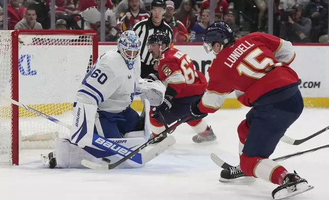 Toronto Maple Leafs goaltender Joseph Woll (60) defends a shot on the goal by Florida Panthers center Anton Lundell (15) during the second period of an NHL hockey game, Tuesday, April 8, 2025, in Sunrise, Fla. (AP Photo/Lynne Sladky)