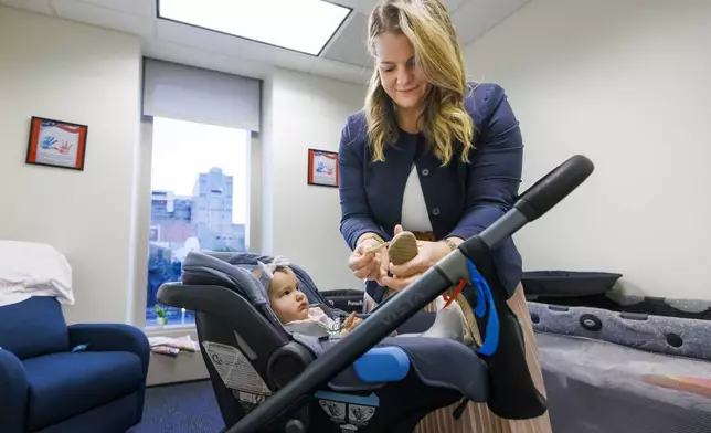 Florida Rep. Fiona McFarland, R-Sarasota, adjusts the shoe of her 7-month-old daughter Grace Melton as she starts her work day at the state Capitol, Thursday, April 17, 2025, in Tallahassee, Fla. (AP Photo/Colin Hackley)