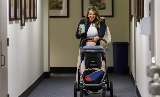 Florida Rep. Fiona McFarland, R-Sarasota, talks to her 7-month-old daughter Grace Melton as she pushes her stroller down the hall to her state Capitol office, Thursday, April 17, 2025, in Tallahassee, Fla. (AP Photo/Colin Hackley)