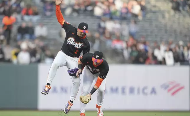 San Francisco Giants second baseman Tyler Fitzgerald, right, fields a base hit by Milwaukee Brewers' Jackson Chourio next to shortstop Willy Adames during the first inning of a baseball game in San Francisco, Tuesday, April 22, 2025. (AP Photo/Jeff Chiu)
