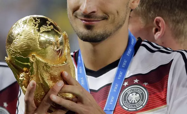 FILE - Germany's Mats Hummels holds the trophy after the World Cup final soccer match between Germany and Argentina at the Maracana Stadium in Rio de Janeiro, Brazil, Sunday, July 13, 2014. (AP Photo/Matthias Schrader, File)