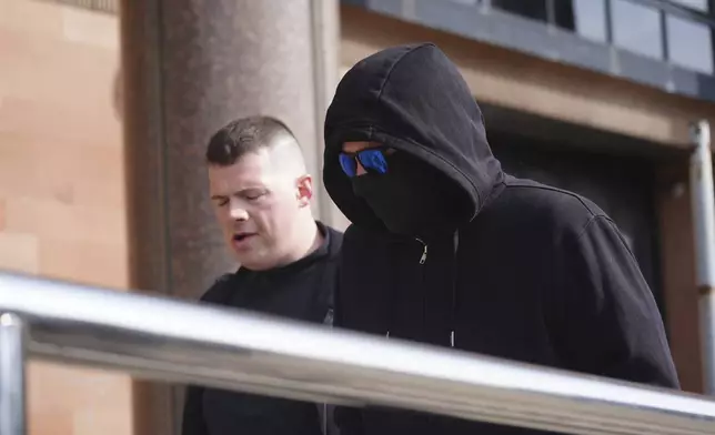 Adam Carruthers, right, arrives at Newcastle Crown Court where he is accused of criminal damage after the felling of the Sycamore Gap tree - valued at £622,000 and £1,114 damage to Hadrian's Wall, in Newcastle, England, Monday April 28, 2025. (Owen Humphreys/PA via AP)