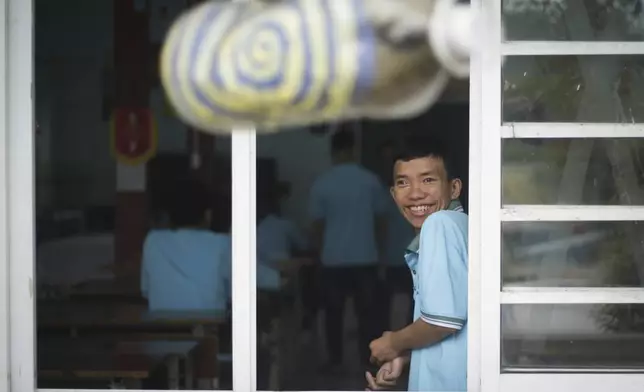 A boy smiles looking out of the window at a school for victims of Agent Orange in Da Nang, Vietnam, March 7, 2025. (AP Photo/Aniruddha Ghosal)