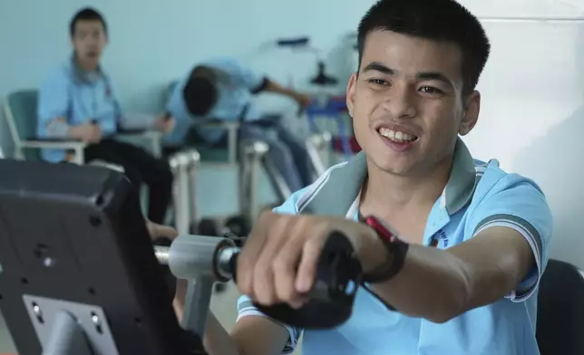 Truong Minh Phu, 20, practices with an arm pedal exerciser in physiotherapy class at a school for victims of Agent Orange in Da Nang, Vietnam, March 7, 2025. (AP Photo/Hau Dinh)