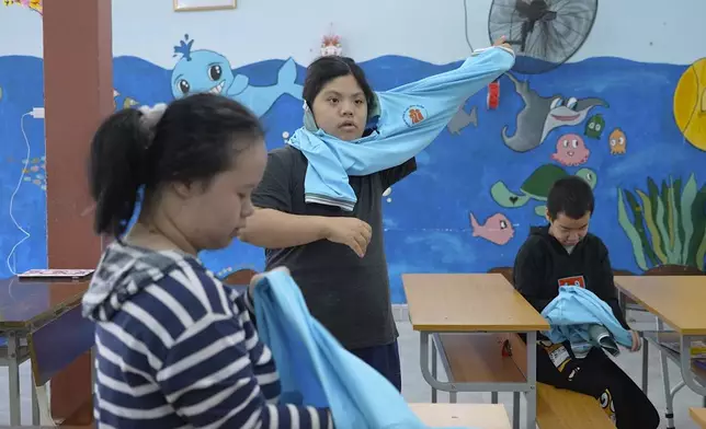 Students put on uniforms at a school for victims of Agent Orange in Da Nang, Vietnam, March 7, 2025. (AP Photo/Hau Dinh)