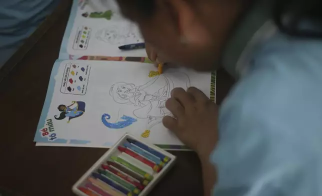 A student fills a colouring book at a school for victims of Agent Orange in Da Nang, Vietnam, March 7, 2025. (AP Photo/Aniruddha Ghosal)