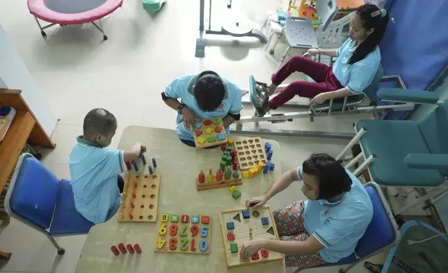Students exercise and play with wooden blocks in physiotherapy class at a school for victims of Agent Orange in Da Nang, Vietnam, March 7, 2025. (AP Photo/Hau Dinh)