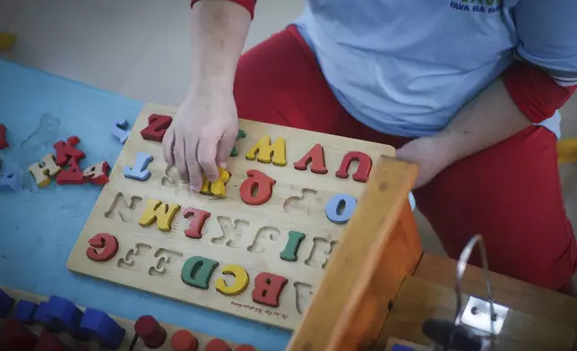 A student plays with a wooden shape sorter at a school for victims of Agent Orange in Da Nang, Vietnam, March 7, 2025. (AP Photo/Hau Dinh)