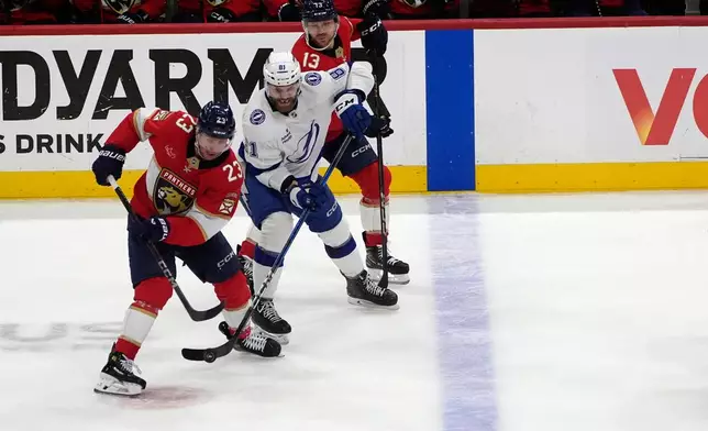 Florida Panthers center Carter Verhaeghe (23) and Tampa Bay Lightning defenseman Erik Cernak (81) go after the puck during the second period in Game 4 of an NHL hockey Stanley Cup first-round playoff series, Monday, April 28, 2025, in Sunrise, Fla. (AP Photo/Marta Lavandier)