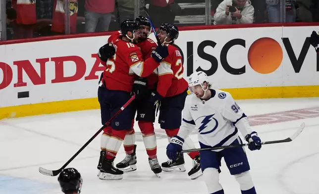 Florida Panthers defenseman Aaron Ekblad, top center, celebrates after his goal during the third period in Game 4 of an NHL hockey Stanley Cup first-round playoff series against the Tampa Bay Lightning, Monday, April 28, 2025, in Sunrise, Fla. (AP Photo/Marta Lavandier)