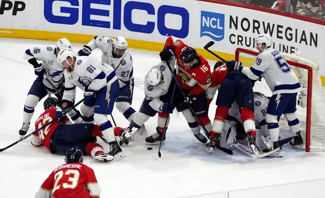 Tampa Bay Lightning center Brayden Point (21) defends Florida Panthers center Aleksander Barkov (16) as he tries a shot on goal during the second period in Game 4 of an NHL hockey Stanley Cup first-round playoff series, Monday, April 28, 2025, in Sunrise, Fla. (AP Photo/Marta Lavandier)