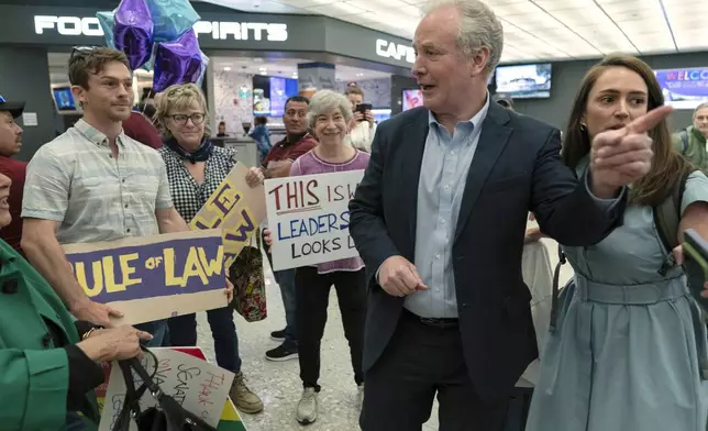Sen. Chris Van Hollen, D-Md., is welcomed by supporters upon his arrival from meeting with Kilmar Abrego Garcia in El Salvador, at Washington Dulles International Airport, in Chantilly, Va., Friday, April 18, 2025. (AP Photo/Jose Luis Magana)