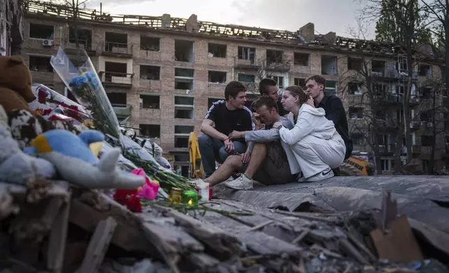 FILE - Friends of Danylo Khudia, 17, who was killed on Thursday by a Russian strike, gather near the rubble of a house in a residential neighborhood in Kyiv, Ukraine, on Friday, April 25, 2025. (AP Photo/Evgeniy Maloletka, File)