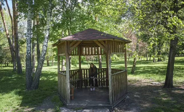 Alyona Zavadska, 16, sits in a gazebo where she had her first date with boyfriend Danylo Khudia, 17, who was killed in a Russian strike on April 24, in Kyiv, Ukraine, on Sunday, April 27, 2025. (AP Photo/Evgeniy Maloletka)