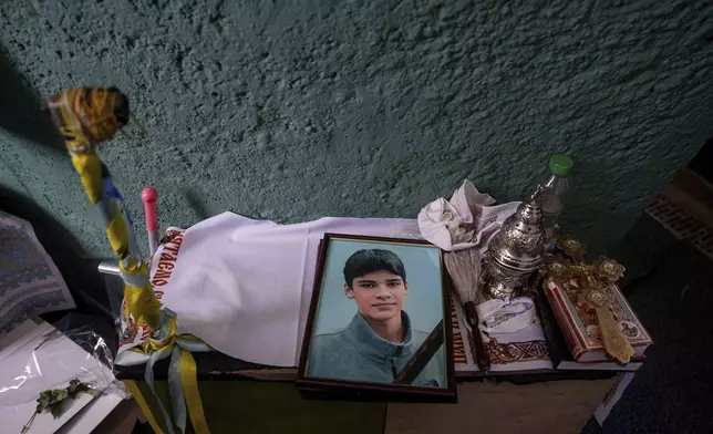 FILE - A photo of Danylo Khudia, 17, killed in a Russian strike along with his parents, Viktoria and Oleh Khudia on April 24, on a table during a farewell ceremony at the crematorium in Kyiv, Ukraine, on Monday, April 28, 2025. (AP Photo/Evgeniy Maloletka, File)