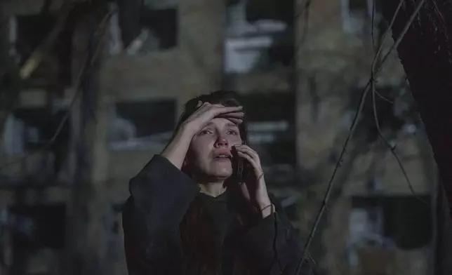 A relative of the Khudia family checks the house, recently destroyed by a Russian airstrike in Kyiv, Ukraine, on Sunday, April 24, 2025. (AP Photo/Evgeniy Maloletka)