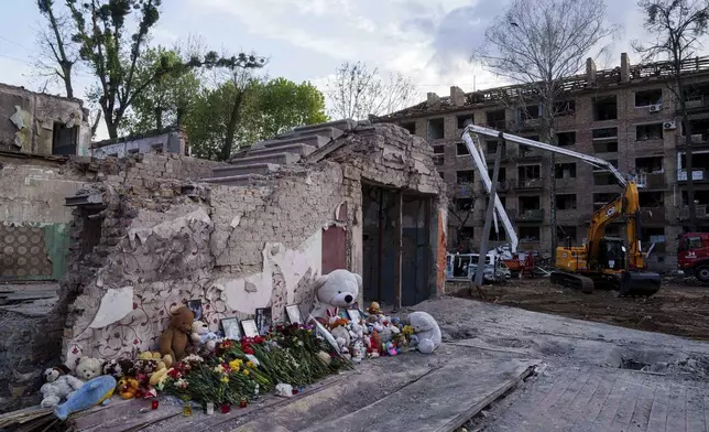 FILE - Flowers and toys are placed at the site of a destroyed house after a Russian strike on a residential neighborhood in Kyiv, Ukraine, on Friday, April 25, 2025. (AP Photo/Evgeniy Maloletka, File)