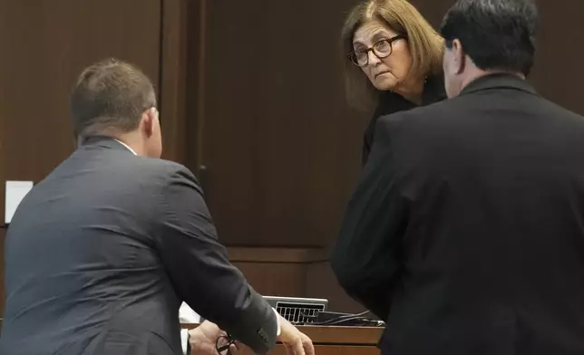 Judge Victoria A. Rossetti, second from right, talks with Lake County, Ill., State's Attorney Eric Rinehart, left, and Robert E. Crimo III's attorney Gregory Ticsay during the sentencing hearing for Robert E. Crimo III., at the Lake County Courthouse, in Waukegan, Ill., Wednesday, April 23, 2025, after pleading guilty in March to killing seven people and injuring dozens more when he opened fire on a 2022 Independence Day parade in Highland Park, Ill. (AP Photo/Nam Y. Huh, Pool)