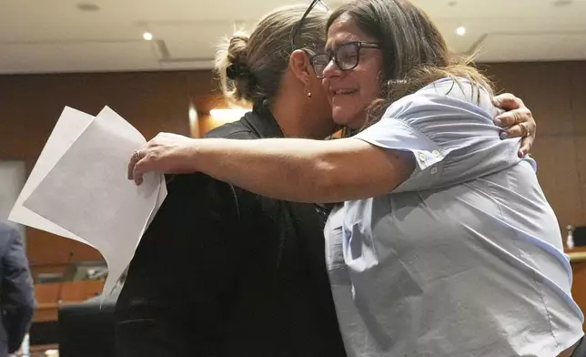 Elizabeth Turnipseed, right, and Melissa Burke, victim specialist of Lake County State's Attorney, hug after reading a victim impact statement during the sentencing hearing for Robert E. Crimo III., at the Lake County Courthouse, in Waukegan, Ill., Wednesday, April 23, 2025. (AP Photo/Nam Y. Huh, Pool)