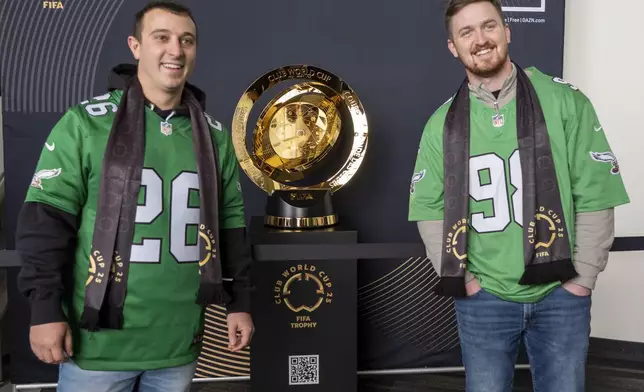 Fans pose with the trophy at a welcoming event for the 2025 FIFA Club World Cup soccer tournament, Thursday, April 10, 2025, in Philadelphia. (AP Photo/Chris Szagola)