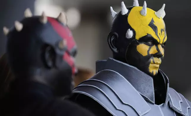 Star Wars fans wearing costumes of Darth Maul, left, and his brother Savage Opress pose for a photo outside the venue during a fan convention called the Star Wars Celebration in Chiba, near Tokyo, Friday, April 18, 2025. (AP Photo/Hiro Komae)