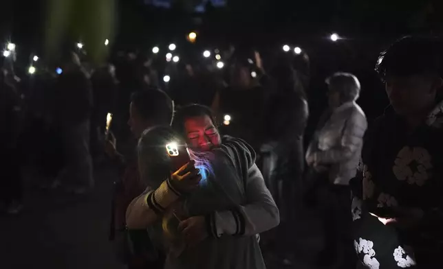 Liza Ahyeng, center right, hugs another attendee at a vigil for victims after a vehicle drove into a crowd during a Filipino heritage festival in Vancouver, British Columbia, Sunday, April 27, 2025. (AP Photo/Lindsey Wasson)