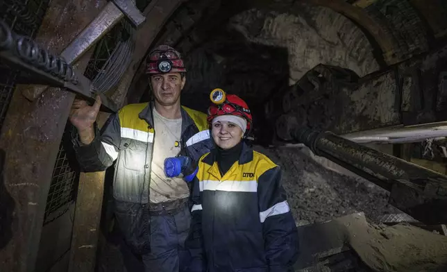 Iryna Ostanko, 37, poses for photo with her husband in tunnel of a coal mine in Dnipropetrovsk region, Ukraine, Jan. 30, 2025. (AP Photo/Evgeniy Maloletka)
