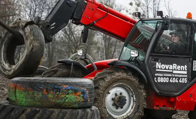 In this image taken from video, student Kateryna Koliadiuk drives a tractor in Nemishaieve, Kyiv region, Ukraine, Dec. 27, 2024. (AP Photo/Vasilisa Stepanenko)