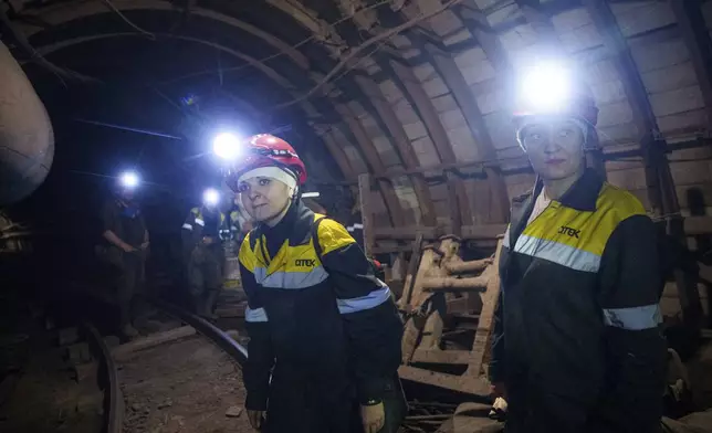 Iryna Ostanko, 37, center, walks in the tunnel of a coal mine in Dnipropetrovsk region, Ukraine, Jan. 30, 2025. (AP Photo/Evgeniy Maloletka)