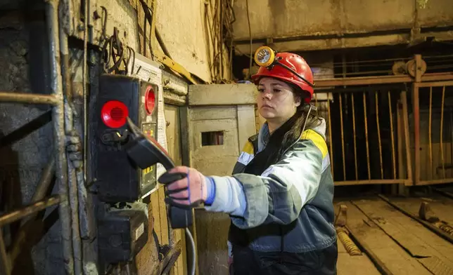 A woman picks up a phone at her work position in a tunnel of a coal mine in Dnipropetrovsk region, Ukraine, Jan. 30, 2025. (AP Photo/Evgeniy Maloletka)