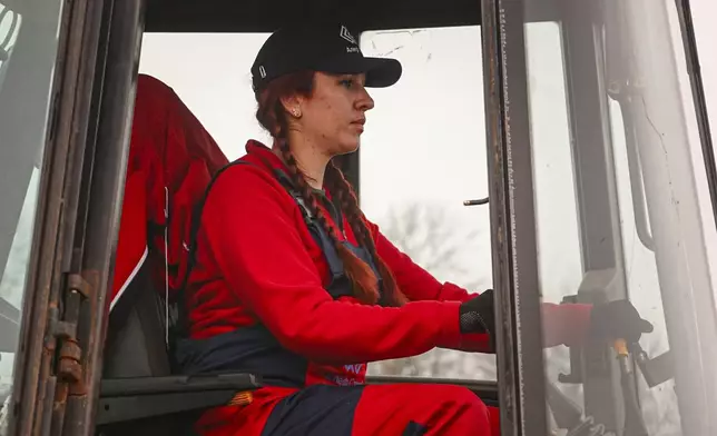 In this image taken from video, a woman operates an excavator during construction work in Nemishaieve, Kyiv region, Ukraine, Dec. 27, 2024. (AP Photo/Vasilisa Stepanenko)