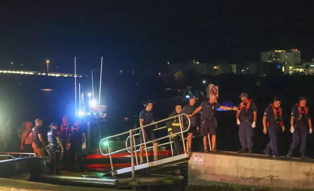Rescue workers gather at the Seminole Boat ramp north of where a boat crashed into the ferry causing multiple injuries near the Clearwater Memorial Causeway Bridge, on Sunday, April 27, 2025, in Clearwater, Fla. (Douglas R. Clifford/Tampa Bay Times via AP)