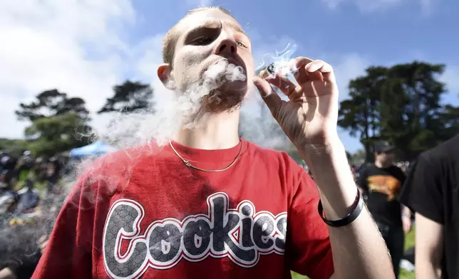 FILE - Kenny Boynton smokes a joint San Francisco, Calif., on Friday, April 20, 2018. (AP Photo/Josh Edelson, file)