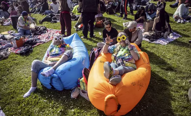 Debbie Harms, left, and Shana LeBlanc enjoy the sun and vibes on Hippie Hill where a Volo Sports, "Peace, Love and Volo Sports" event that coincided with Easter gatherings, and an unofficial 420 gathering at Robin Williams Meadow in Golden Gate Park in San Fr, on Sunday, April 20, 2025. (Carlos Avila Gonzalez/San Francisco Chronicle via AP)