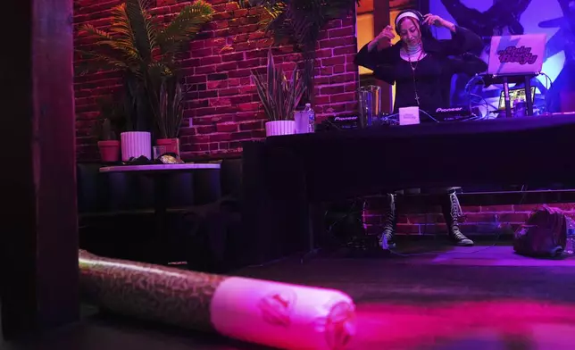 DJ Baby Van Beezly performs dressed as a nun as an inflatable joint sits on the floor during a "Bad Habits" Easter and 420-themed event at Queer/Bar Sunday, April 20, 2025, in Seattle. (AP Photo/Lindsey Wasson)