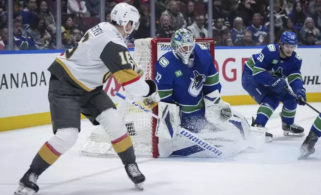 Vancouver Canucks goalie Kevin Lankinen (32) stops Vegas Golden Knights' Pavel Dorofeyev (16) during the second period of an NHL hockey game in Vancouver, on Wednesday, April 16, 2025. (Darryl Dyck/The Canadian Press via AP)