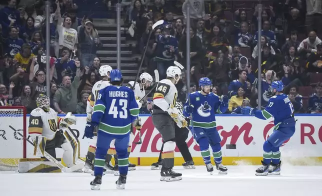 Vancouver Canucks' Pius Suter, back second right, and Filip Hronek, right, celebrate Suter's goal against the Vegas Golden Knights during the first period of an NHL hockey game in Vancouver, on Wednesday, April 16, 2025. (Darryl Dyck/The Canadian Press via AP)