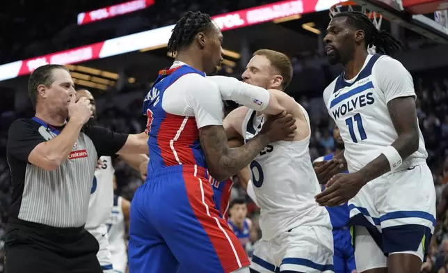 CORRECTS TO PISTONS FORWARD RONALD HOLLAND II NOT CENTER JALEN DUREN - Detroit Pistons forward Ronald Holland II, center left, and Minnesota Timberwolves guard Donte DiVincenzo, center right, fight during the first half of an NBA basketball game, Sunday, March 30, 2025, in Minneapolis. (AP Photo/Abbie Parr)