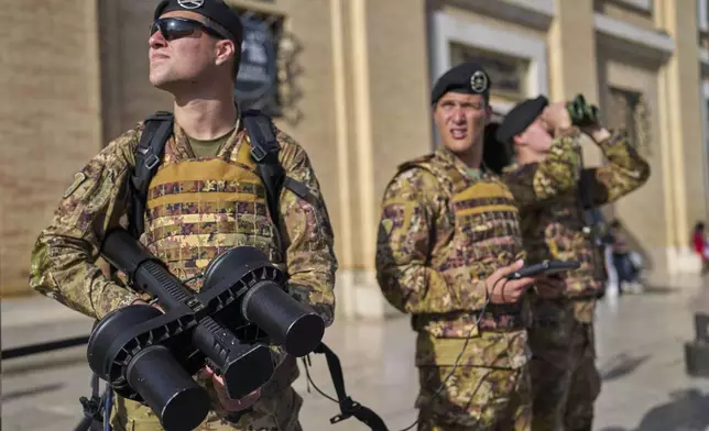 Italian army soldiers carrying an anti drone gun patrol the area in front of St. Peter's Square before a rosary prayer for the late Pope Francis, in Rome Tuesday, April 22, 2025. (AP Photo/Bernat Armangue)