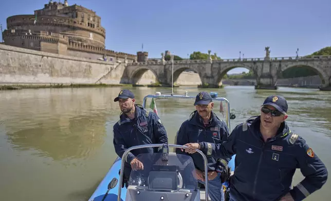 Italian police officers on a dinghy boat patrol for security the Tiber river near the Vatican, with the Sant'Angelo castle in the background, Tuesday, April 22, 2025. (AP Photo/Bernat Armangue)