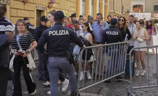 Italian police officers monitor the flow of near the Vatican, Tuesday, April 22, 2025. (AP Photo/Andrew Medichini)