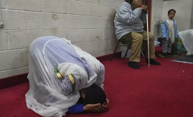A congregant kneels to pray during a service at Re'ese Adbarat Debre Selam Kidist Mariam Church, an Ethiopian Orthodox Tewahedo church, in Washington, D.C., Saturday, April 5, 2025. (AP Photo/Jessie Wardarski)