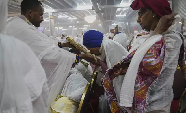A congregant bows to kiss the holy Gospel during a service at Re'ese Adbarat Debre Selam Kidist Mariam Church, an Ethiopian Orthodox Tewahedo church, in Washington, D.C., Saturday, April 5, 2025. (AP Photo/Jessie Wardarski)