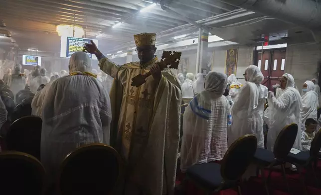 A kesis or priest, waves a censer burning incense as he walks through rows of congregants at Re'ese Adbarat Debre Selam Kidist Mariam Church, an Ethiopian Orthodox Tewahedo church, in Washington, D.C., Saturday, April 5, 2025. (AP Photo/Jessie Wardarski)
