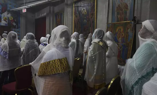 Congregants wear netela, a white scarf-like cotton cloth that signifies modesty and purity, during a service at Re'ese Adbarat Debre Selam Kidist Mariam Church, an Ethiopian Orthodox Tewahedo church, in Washington, D.C., Saturday, April 5, 2025. (AP Photo/Jessie Wardarski)