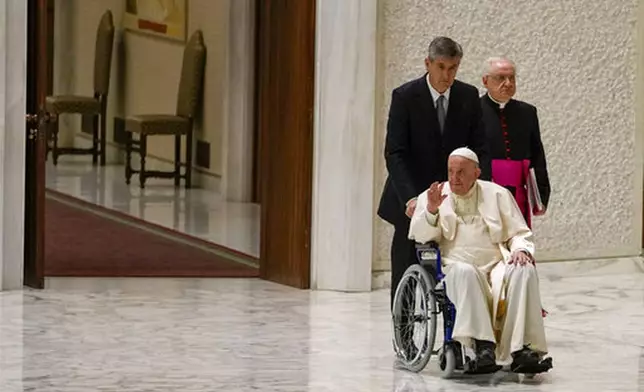 FILE - Pope Francis arrives in a wheelchair to attend an audience with nuns and religious superiors in the Paul VI Hall at The Vatican with his aide Monsignor Leonardo Sapienza, right, Thursday, May 5, 2022. (AP Photo/Alessandra Tarantino, File)