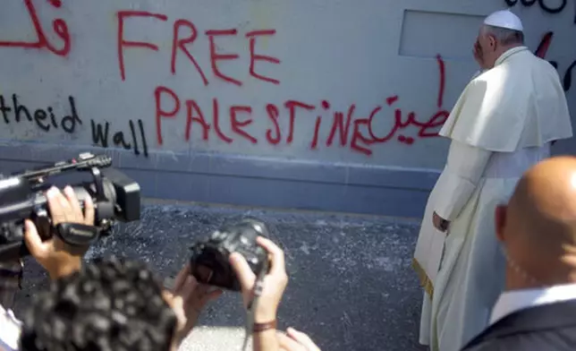 FILE - Pope Francis prays at Israel's separation barrier on his way to a Mass in Manger Square next to the Church of the Nativity, traditionally believed to be the birthplace of Jesus Christ, in the West Bank city of Bethlehem, Sunday, May 25, 2014. (AP Photo/Ariel Schalit, file)
