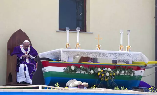 FILE - Pope Francis celebrates a Mass in front of an altar made with recycled wood from a broken migrant boat, during his visit to the island of Lampedusa, southern Italy, Monday, July 8, 2013. (AP Photo/Alessandra Tarantino, file)
