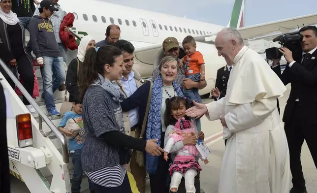FILE - Pope Francis greets a group of Syrian refugees, arrived with the pontiff's charter plane after the pope's visit to the Greek island of Lesbos, at Rome Ciampino airport, Saturday, April 16, 2016. (Filippo Monteforte/Pool Photo via AP, file)
