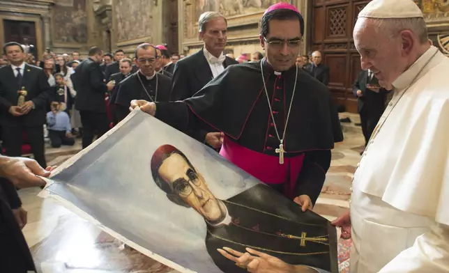 FILE - Pope Francis is presented with an image of Roman Catholic Archbishop Oscar Romero during a private audience granted to participants to the pilgrimage from El Salvador at the Vatican, Tuesday, Oct. 20, 2015. (L'Osservatore Romano/Pool Photo via AP, file)